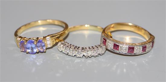 An 18ct gold diamond, ruby and diamond seven stone half hoop ring, a similar tanzanite and diamond ring and one other ring.